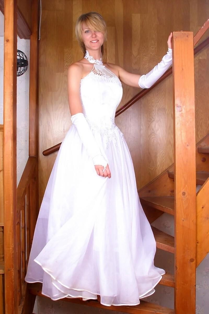 Fille blonde dans les escaliers en robe de mariée