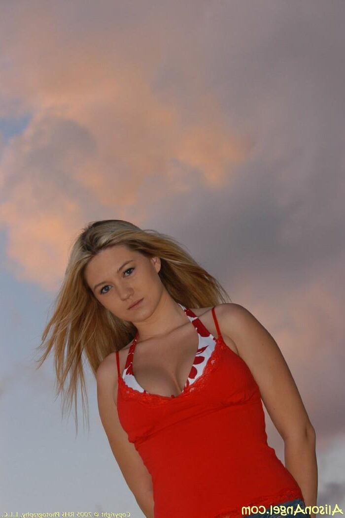 Alison se mamas na praia