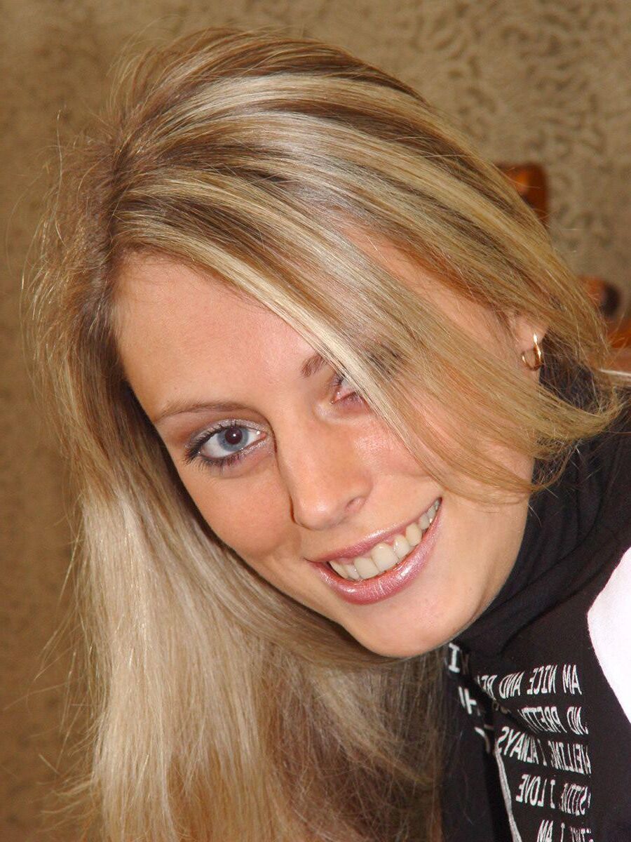 Blonde en casseroles en jeans jouant avec un gode