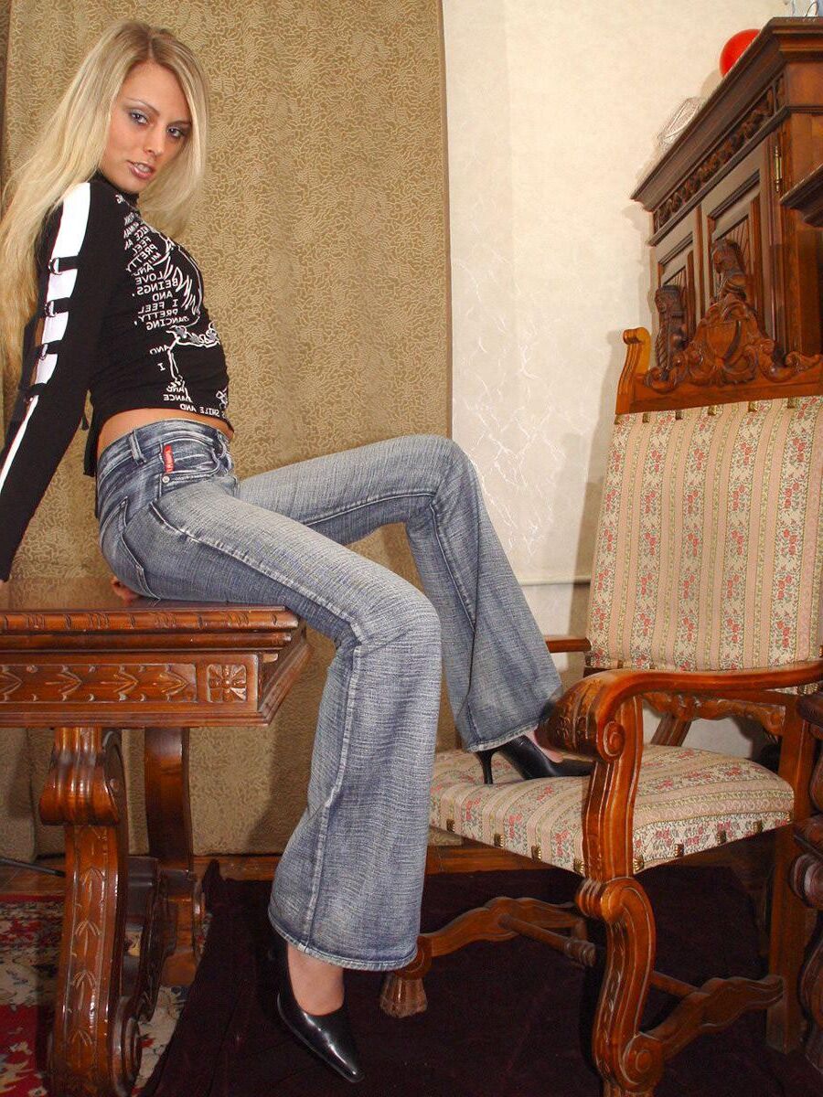 Blonde en casseroles en jeans jouant avec un gode