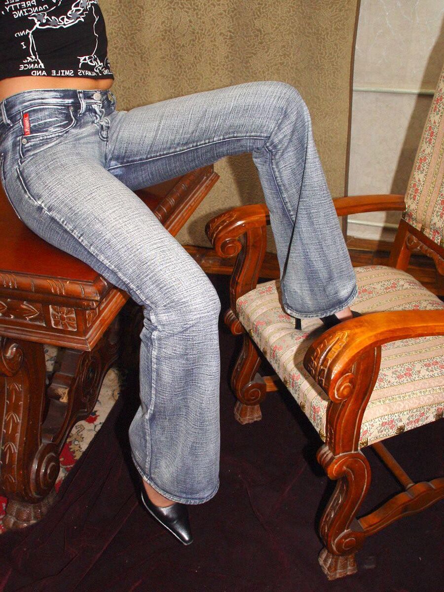 Blonde en casseroles en jeans jouant avec un gode