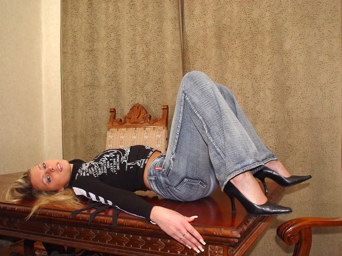 Blonde en casseroles en jeans jouant avec un gode