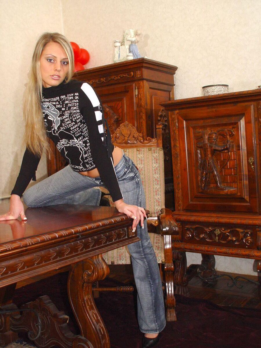 Blonde en casseroles en jeans jouant avec un gode